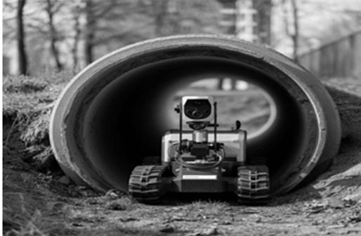 Tracked CCTV crawler robot entering a concrete pipe